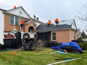 Ground view of L&S workers in bright orange working on roof