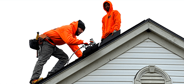 L&S team in bright orange working on a roof