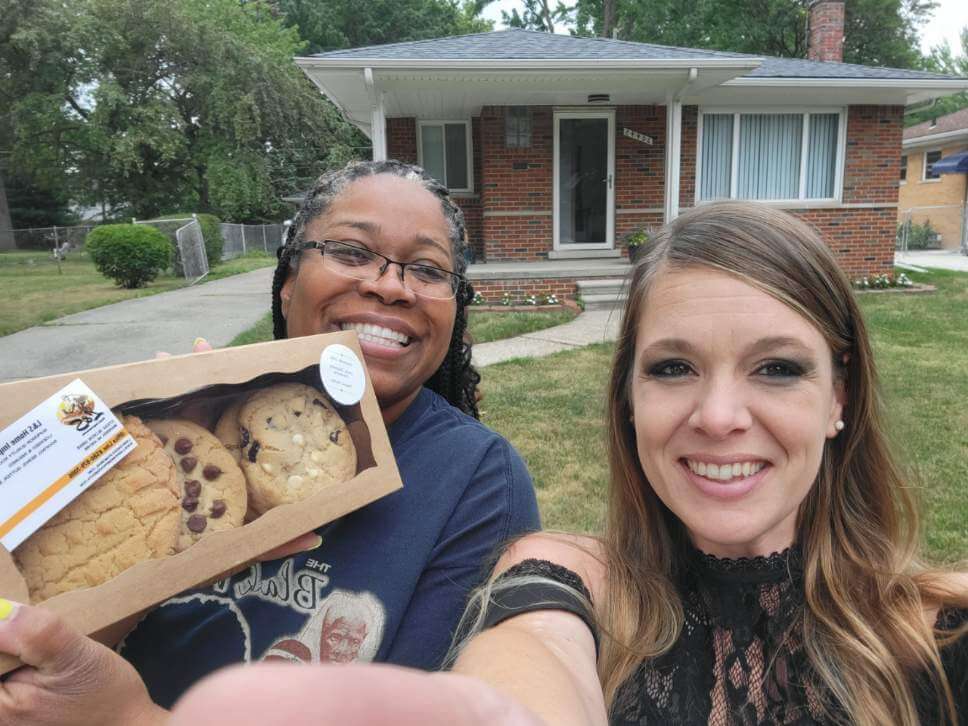 Selfie style photo of Kathryn with happy customer who received cookies