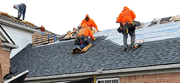 L&S team in bright orange working on a roof