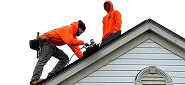 L&S team in bright orange working on a roof