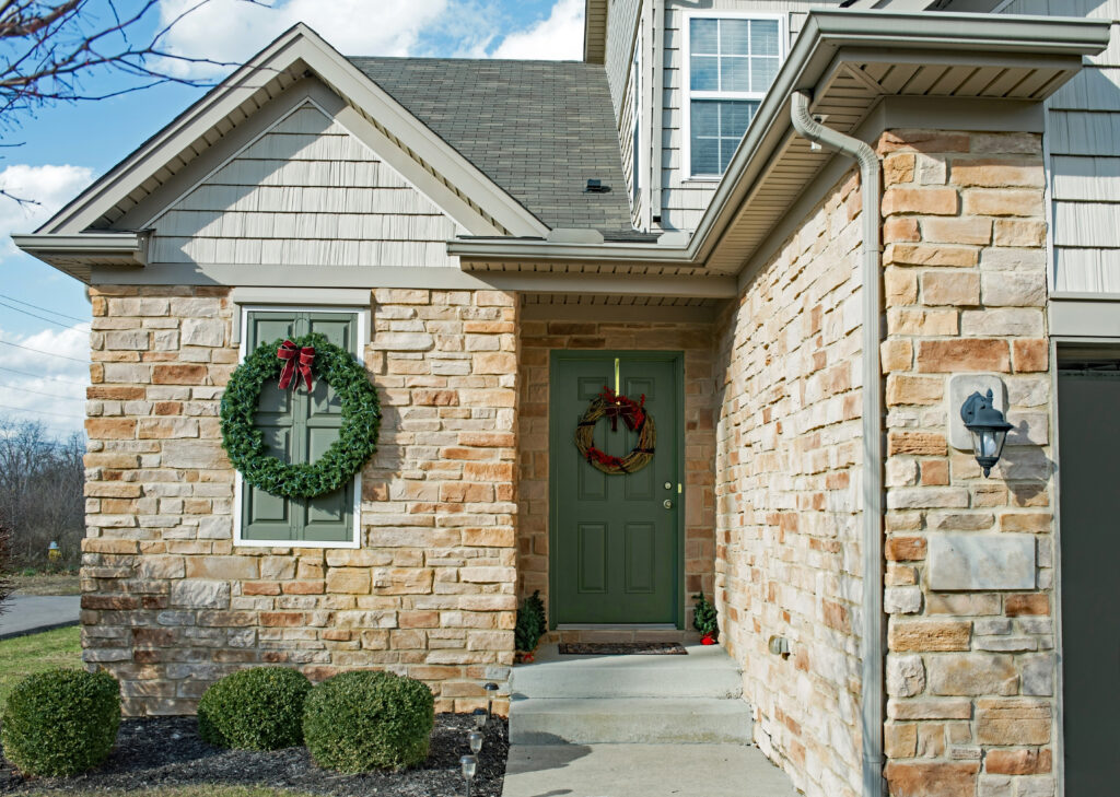 The front entrance of a two-story home with a combination of stone and cedar shake siding. 