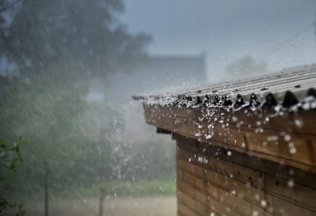 Rain pours down on a metal roof