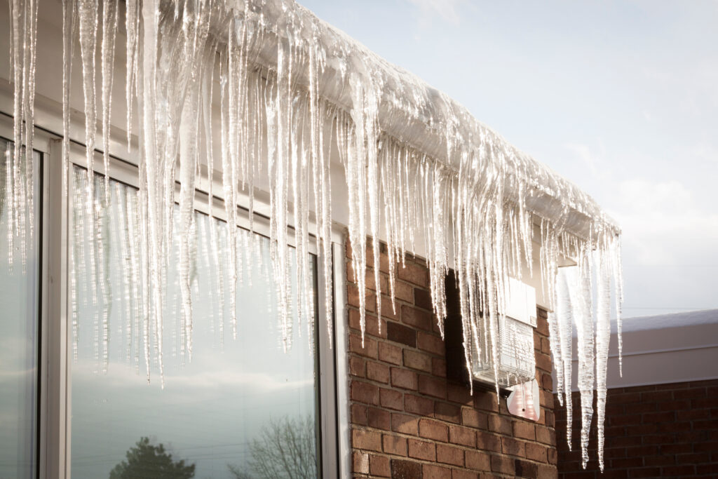 A row of icicles hangs from the gutters of a home