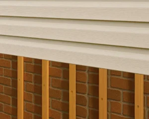 Wood furring strips are placed over brick. Vinyl siding is being installed over the furring strips.