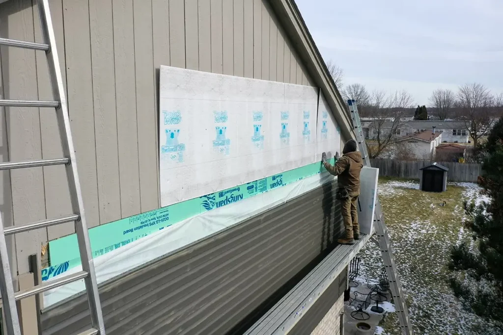 L&S Home Improvements worker installing new siding on a home