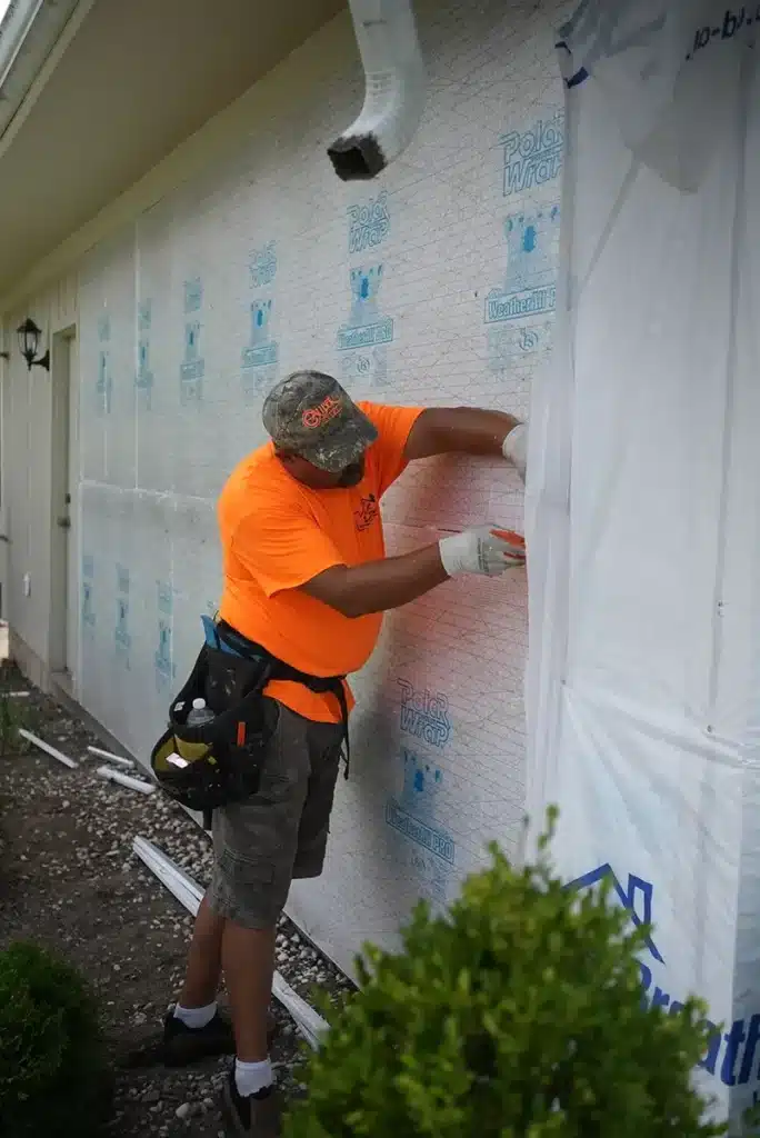 L&S Home Improvements worker preparing to add new siding to a home