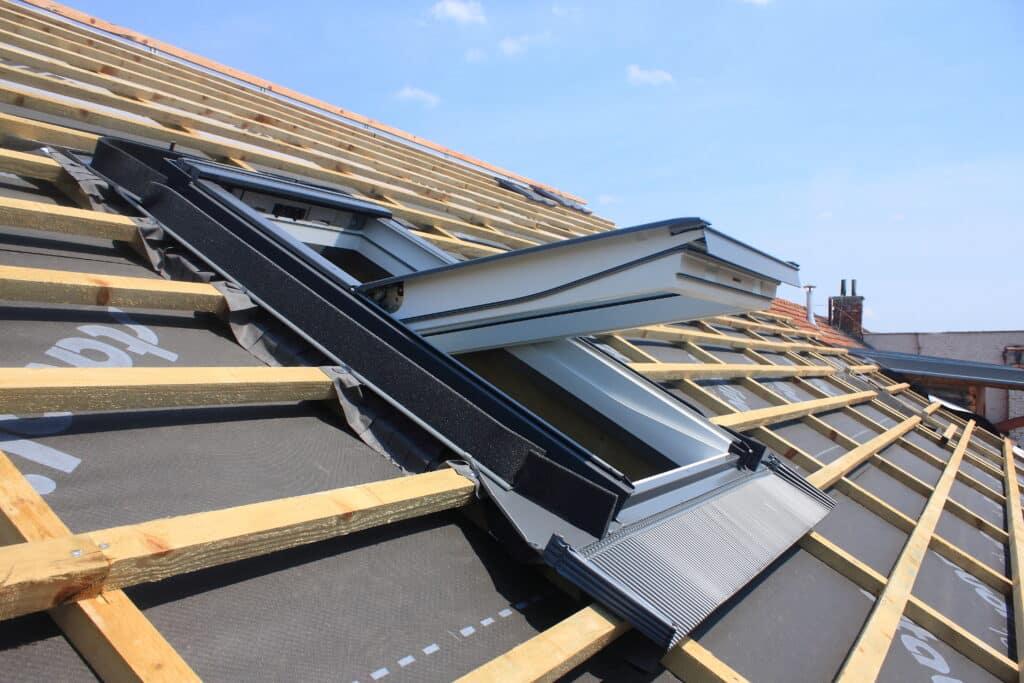 A skylight is being installed with a new roof. The shingles have not yet been installed