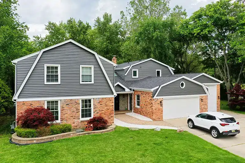 Drone view of the front of a home with a new roof and siding